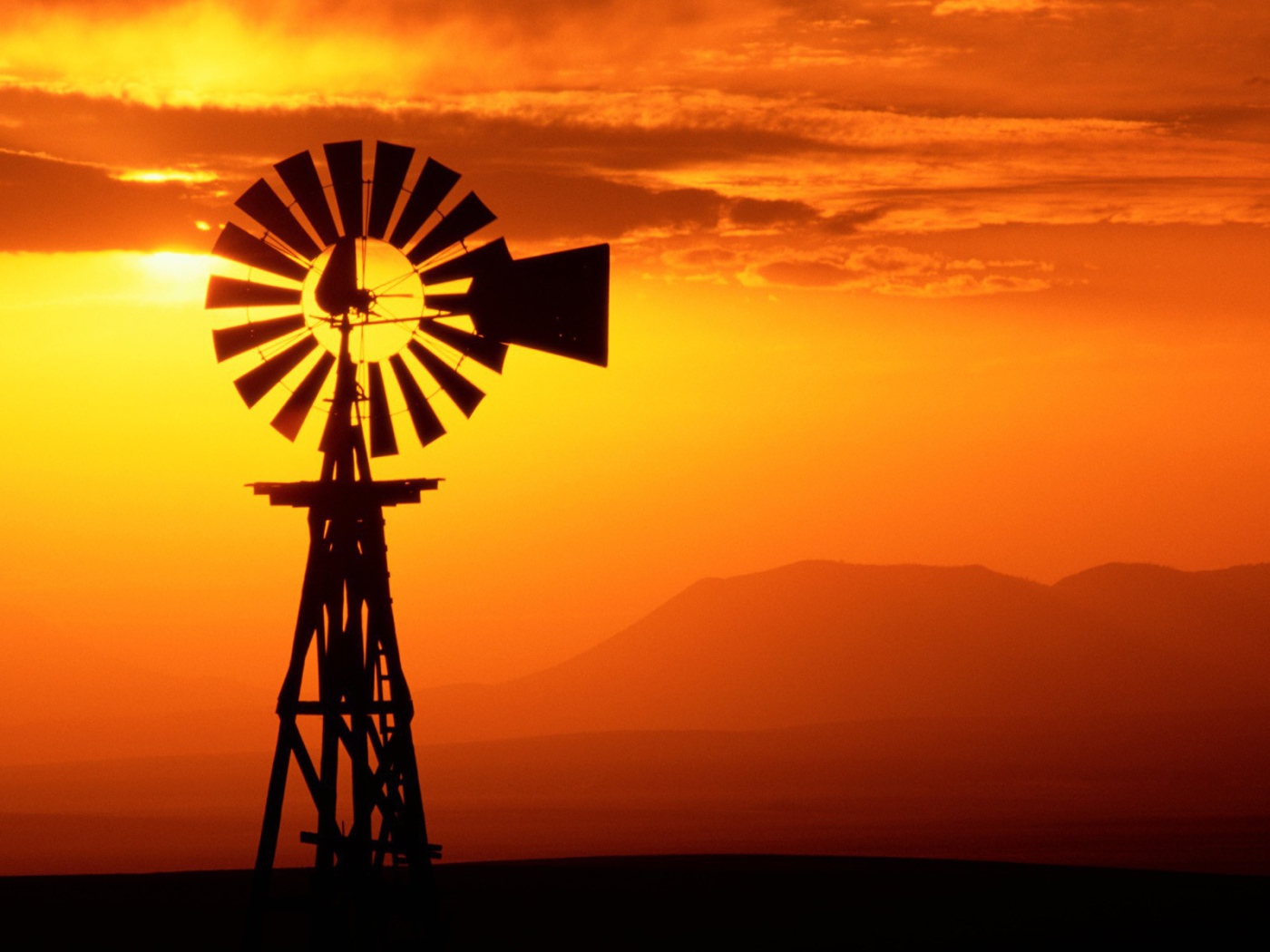 Ветряк флюгер на фоне заката, США
