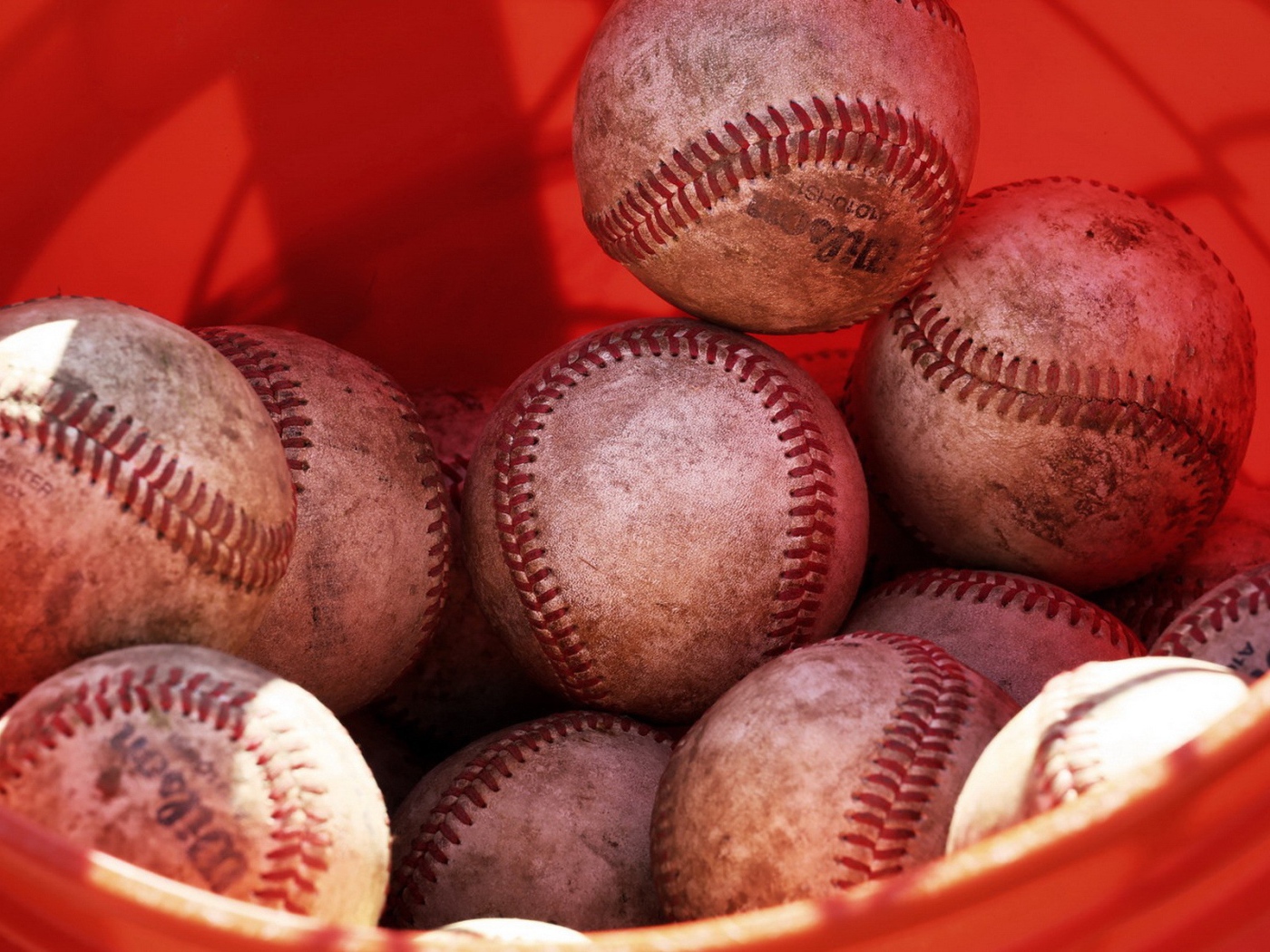 Красное ведро с мячами для бейсбола