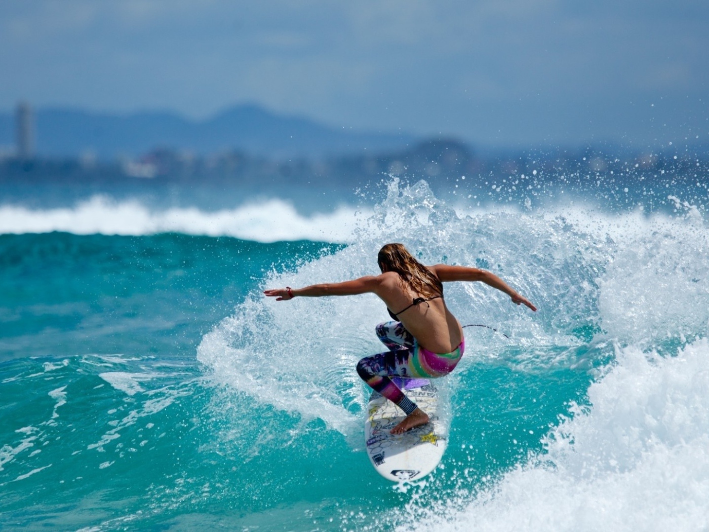 Surfer girl straddled the blue wave