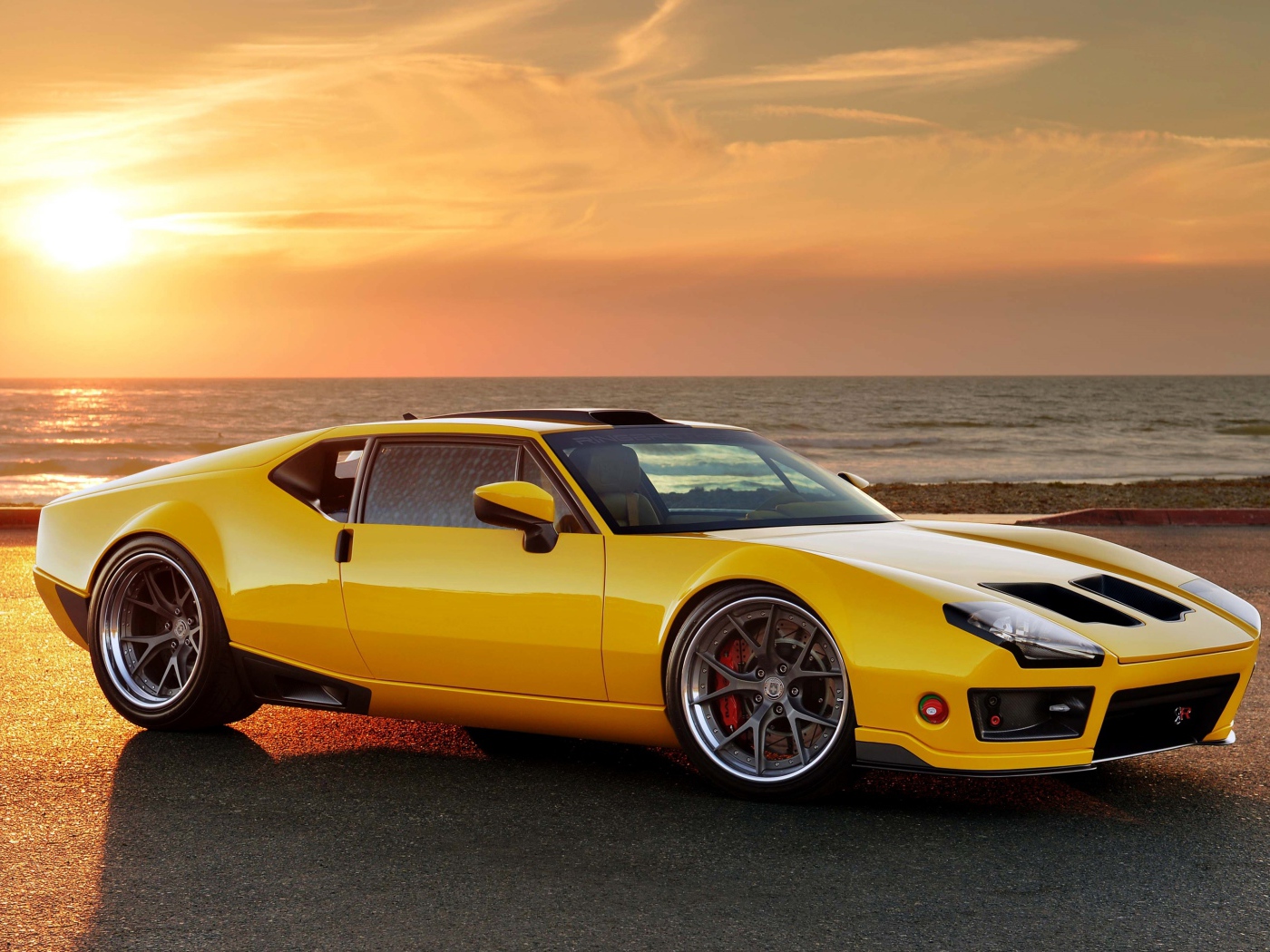 Желтый спортивный автомобиль De Tomaso Pantera на фоне заката