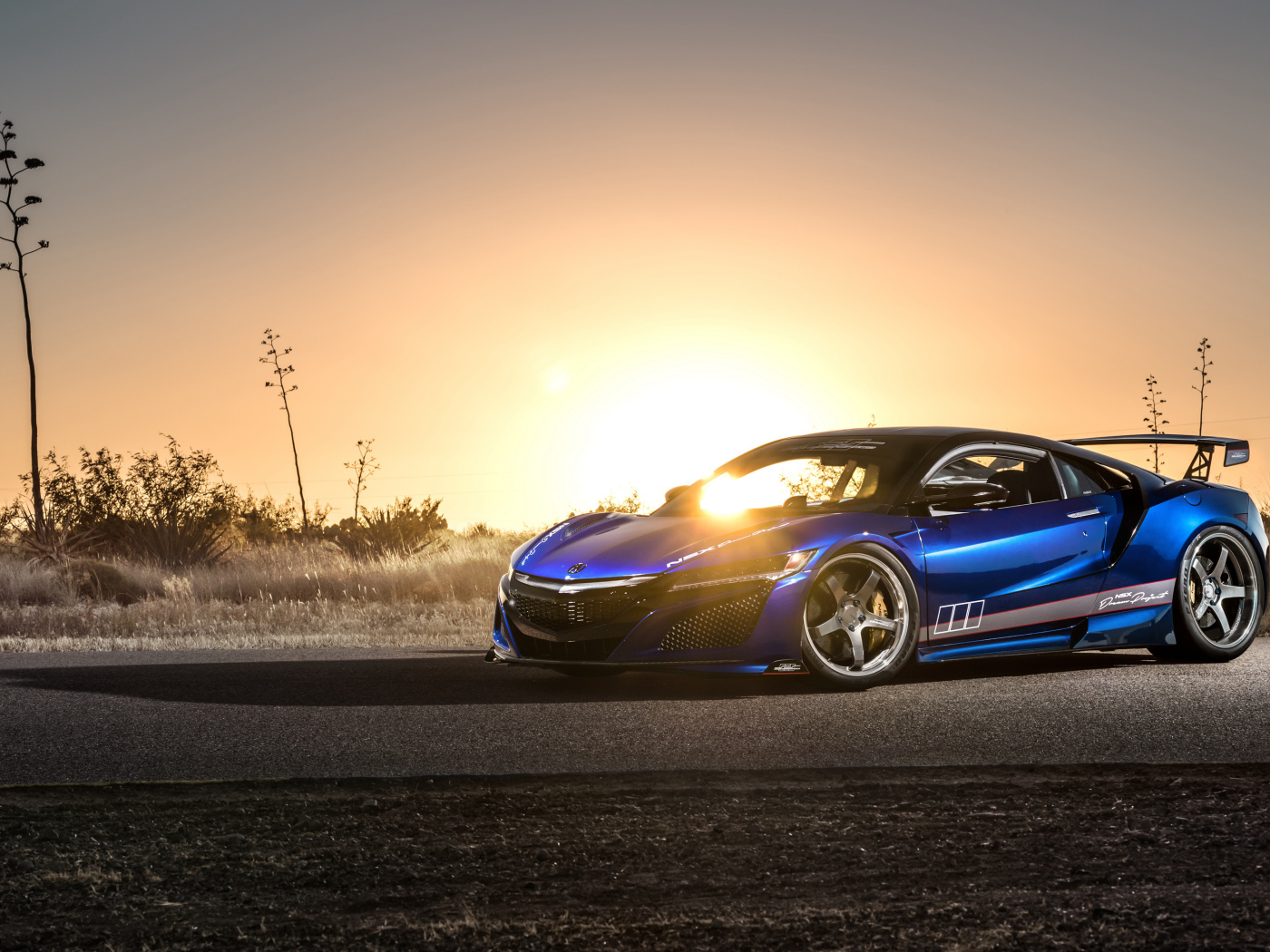 Blue sports car Acura NSX, 2017 in the background of a bright sun