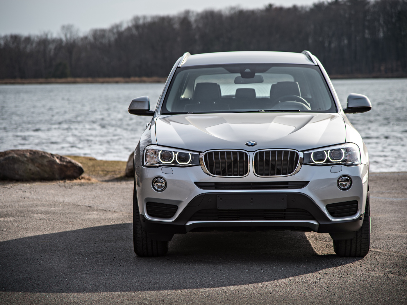 Серебристый автомобиль BMW X3 у водоема 