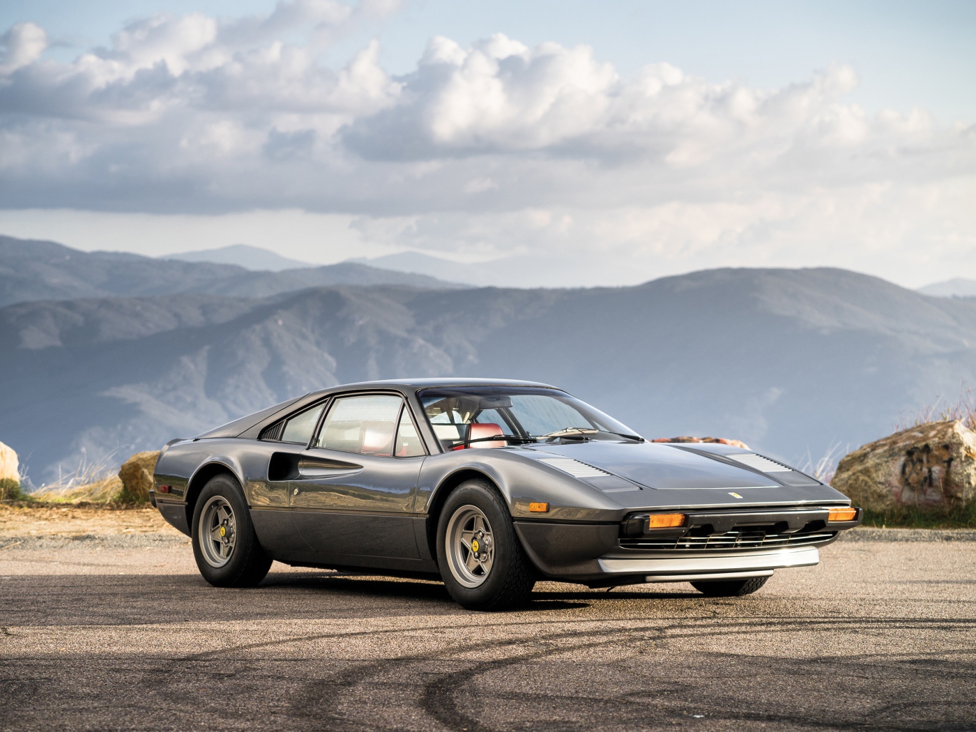 Суперкар Ferrari 308 gts серого цвета,   на фоне гор 