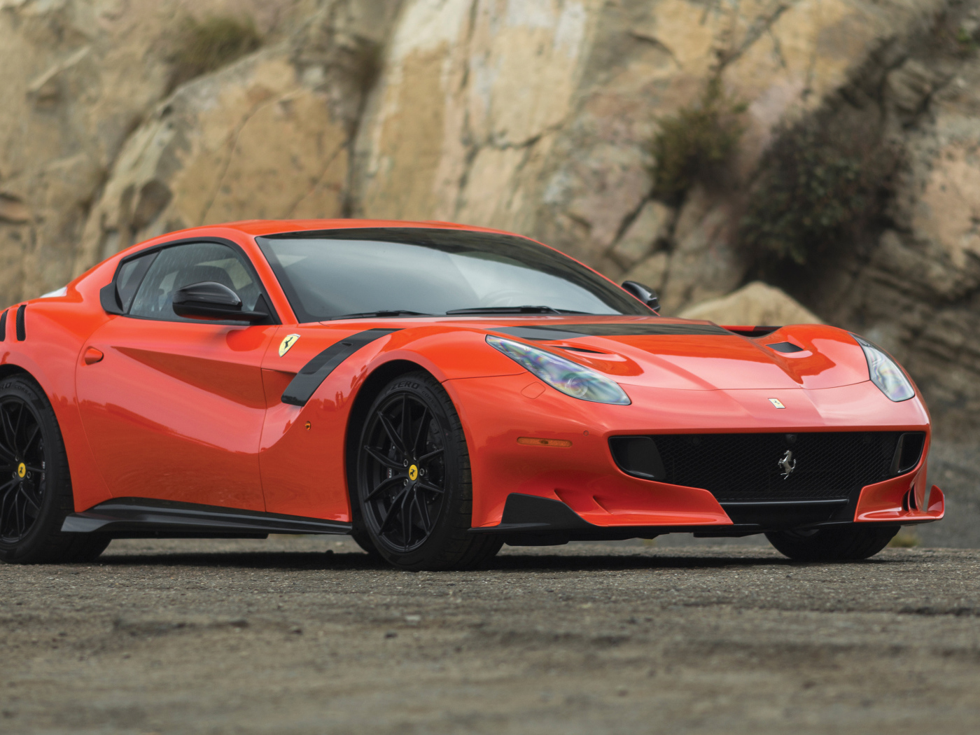 Красный спортивный автомобиль Ferrari F12tdf, 2017 у скалы