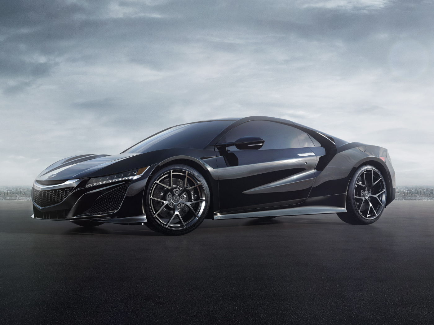 Черный спортивный автомобиль Honda NSX под пасмурным небом