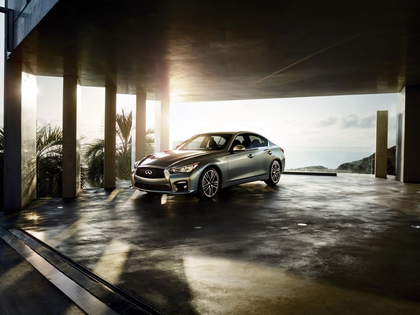 Серебристый автомобиль Infiniti Q50 в лучах солнца 