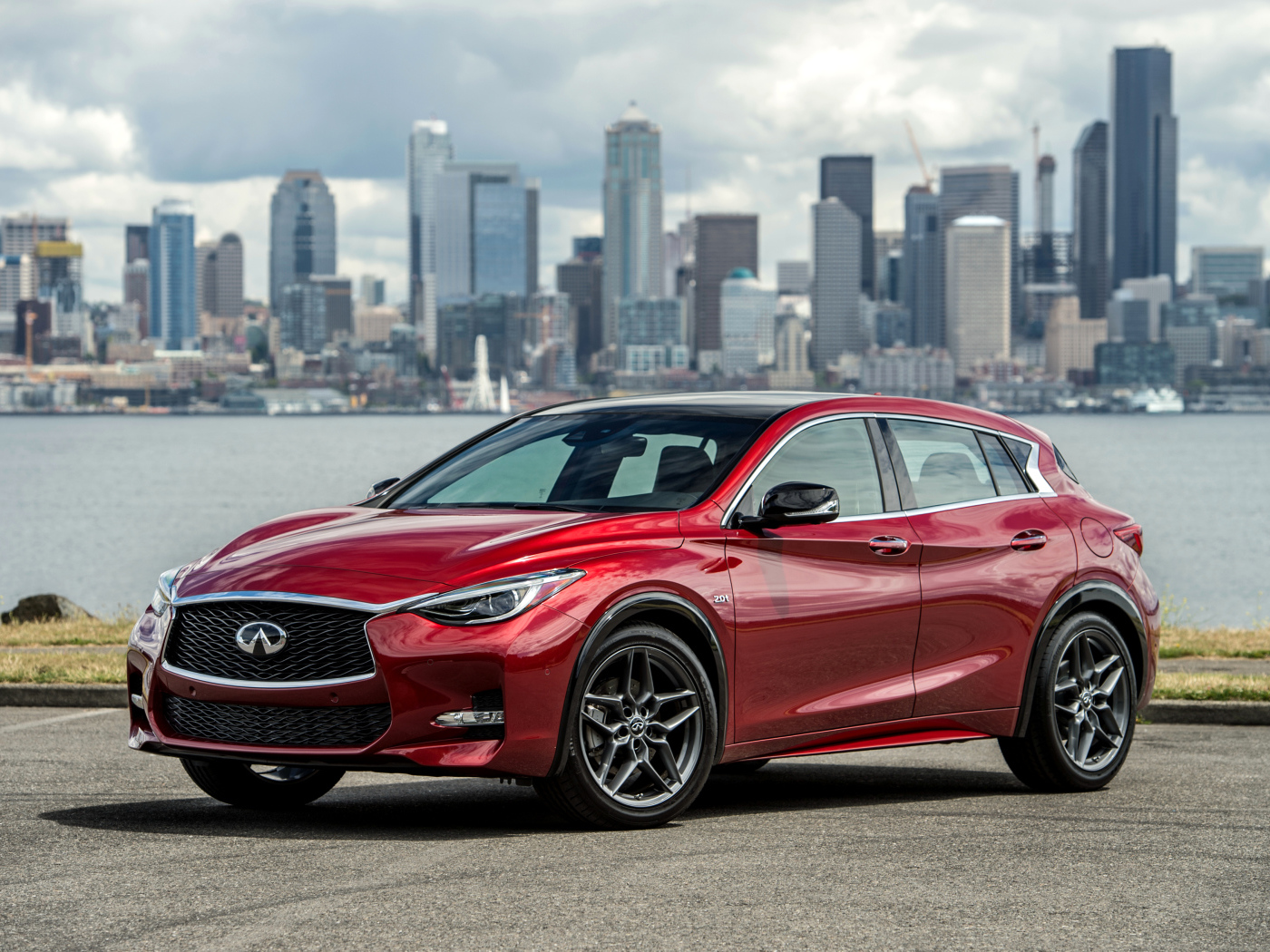 Бордовый автомобиль Infiniti QX30S 2.0t, 2017 на фоне города 