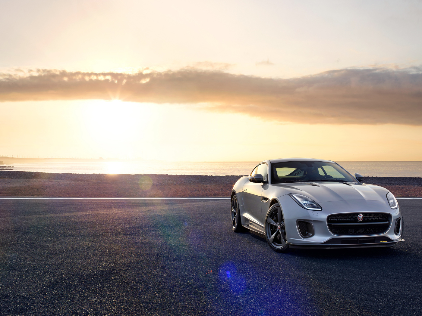 Серебристый автомобиль Jaguar F-Type на фоне неба 