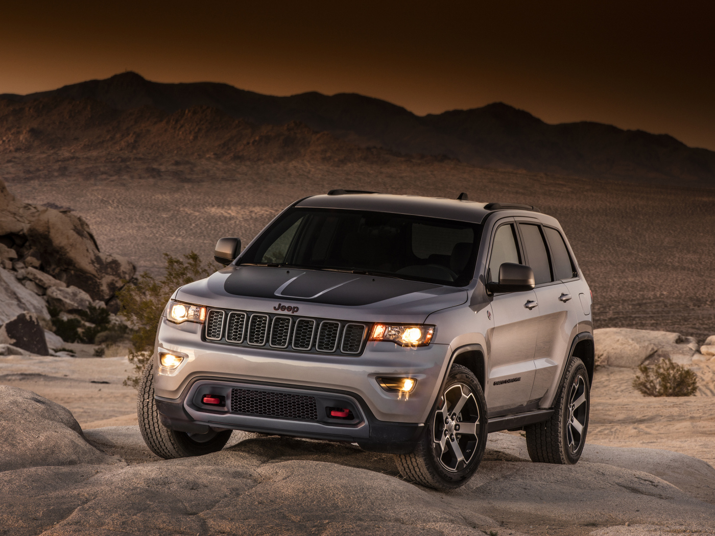 Серебристый внедорожник Jeep Grand Cherokee в пустыне 