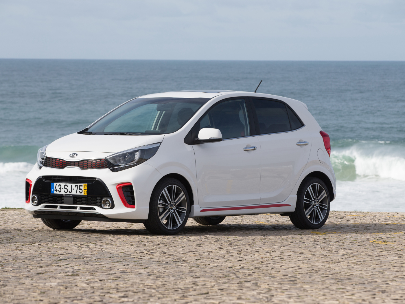 Белый автомобиль KIA Picanto GT Line, 2017 на фоне океана 
