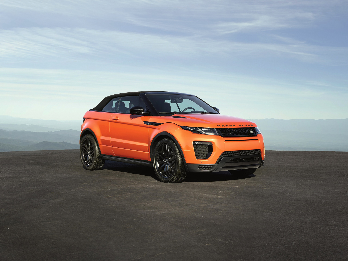 Оранжевый автомобиль Range Rover Evoque на фоне горизонта