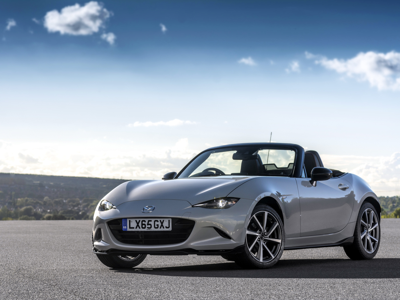 Серебристый кабриолет Mazda MX-5 на фоне красивого неба