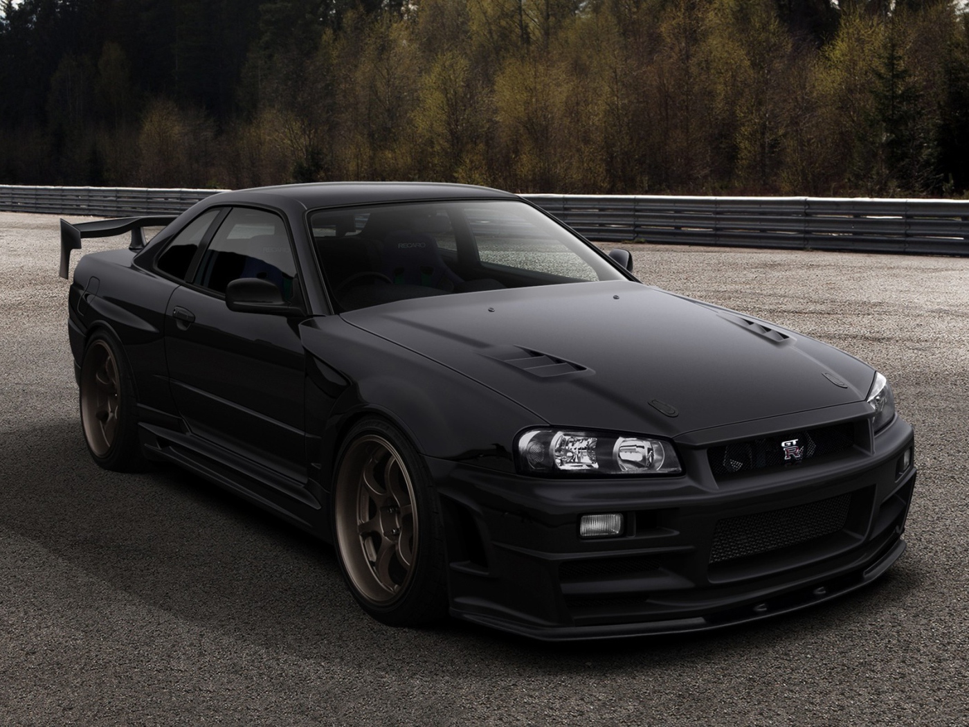 Черный автомобиль Nissan Skyline GT-R R34 на трассе