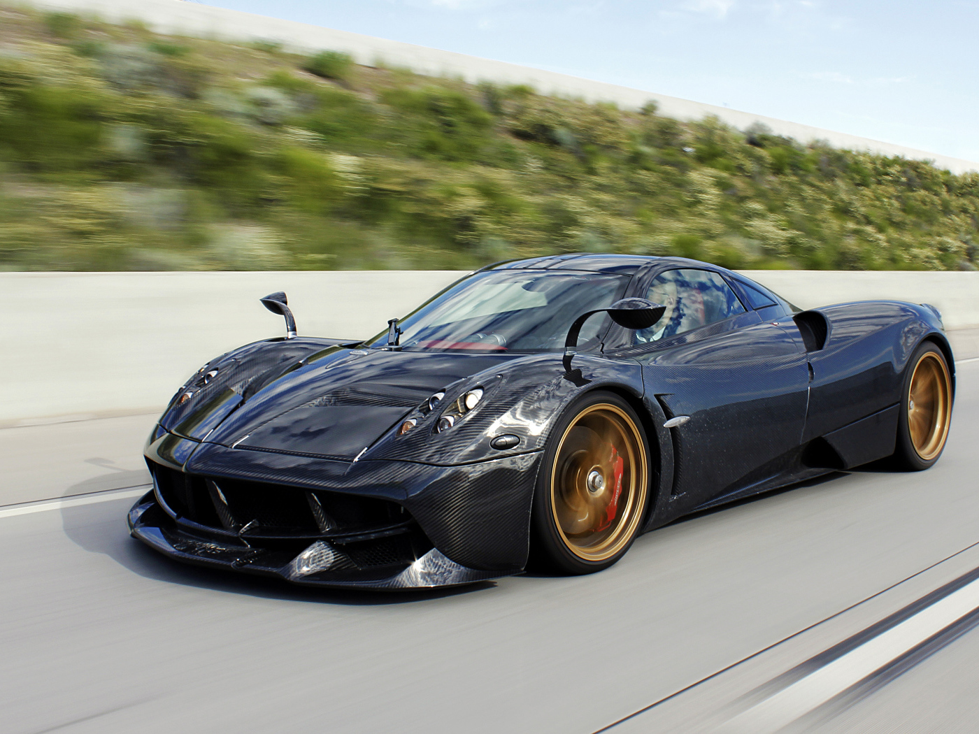 Черный спортивный автомобиль Pagani Huayra на трассе 