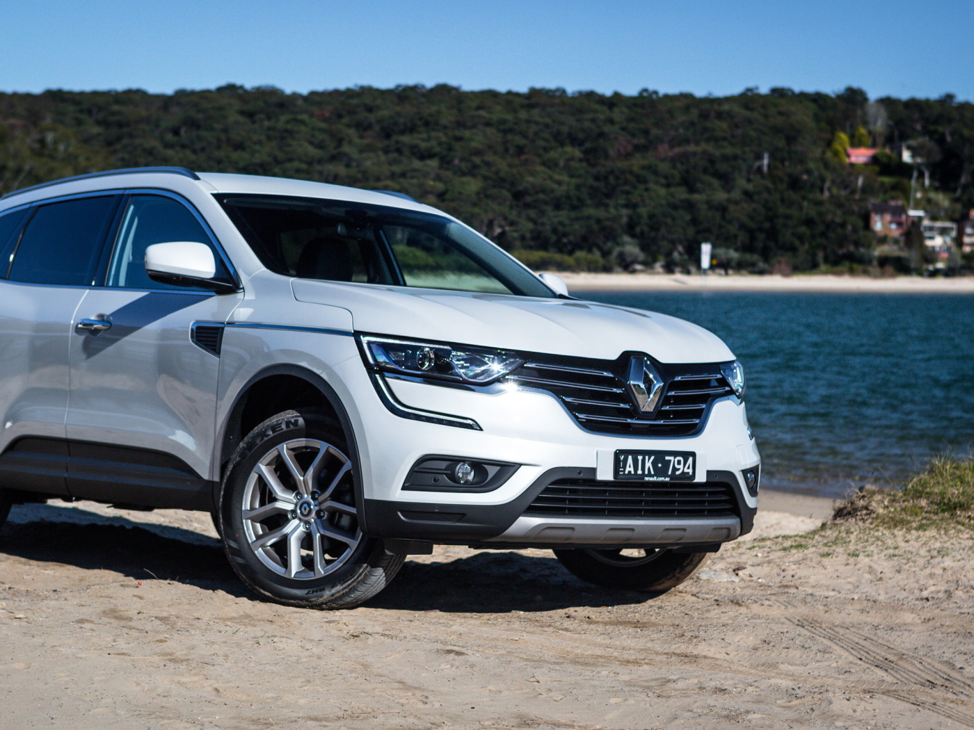 Белый автомобиль Renault Koleos у водоема