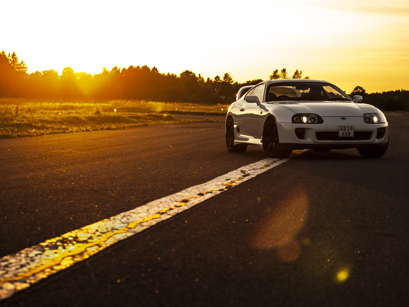 Белый автомобиль Toyota Supra стоит на трассе на рассвете