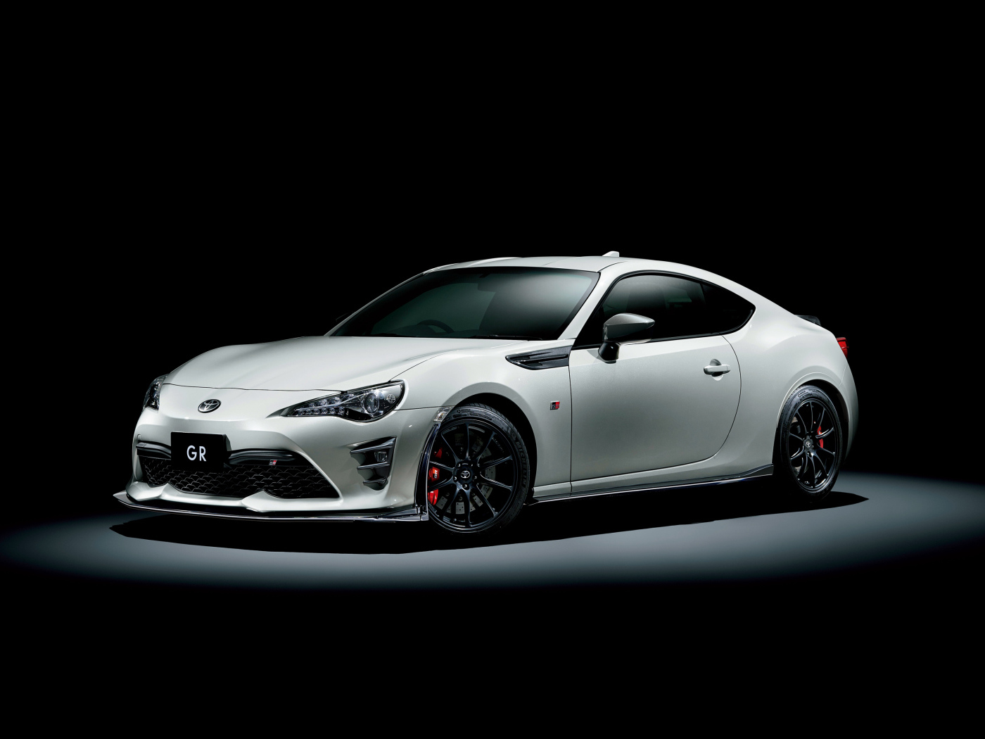 Белый спортивный автомобиль Toyota 86 GR на черном фоне