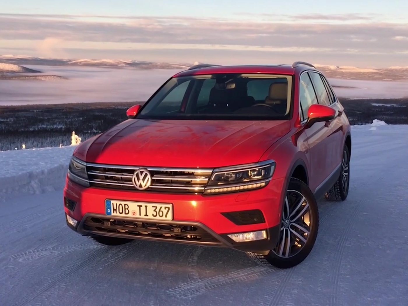Красный Volkswagen Tiguan 2017 года на заснеженной трассе 