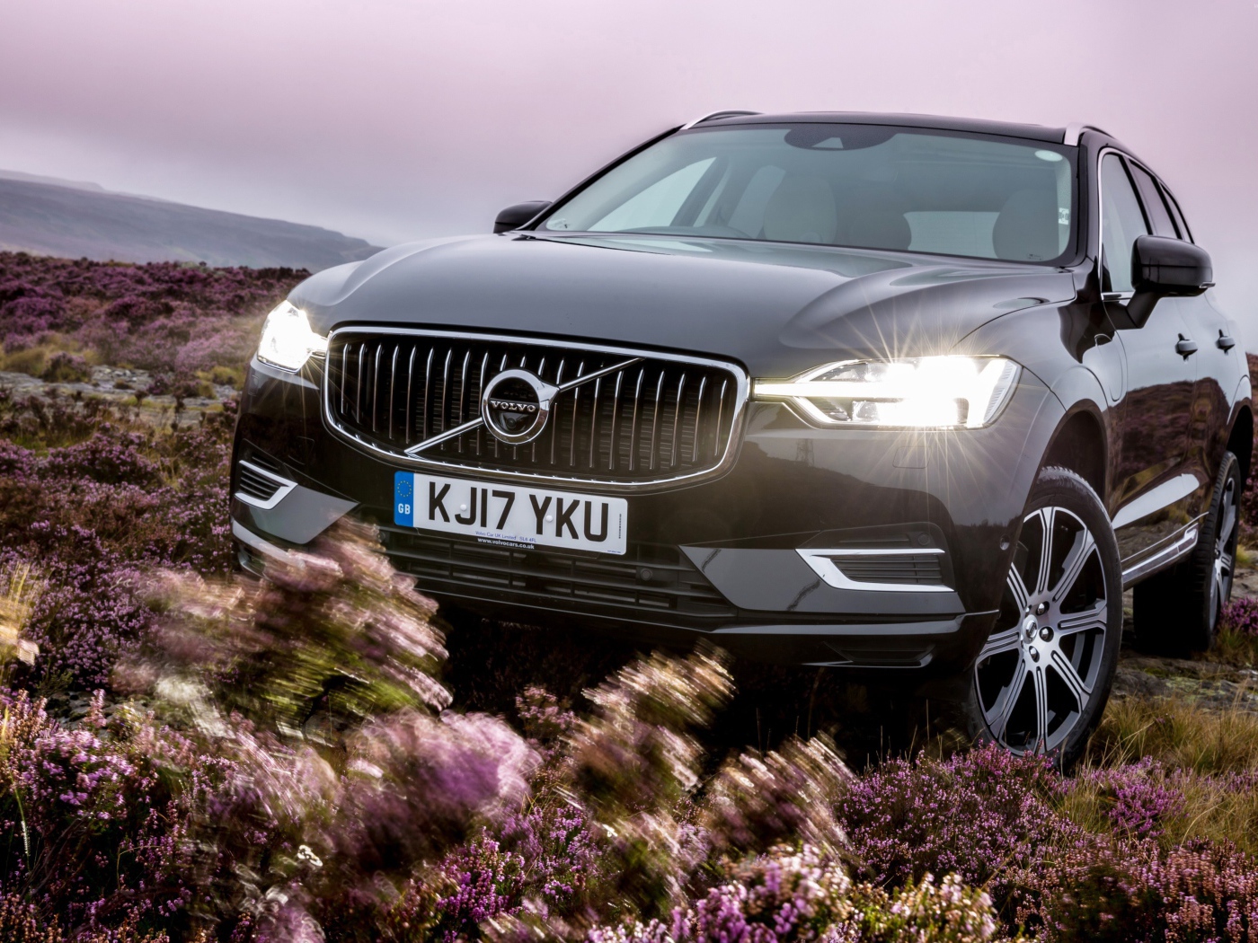 Черный автомобиль Volvo XC60 T8, 2018 с включенными фарами