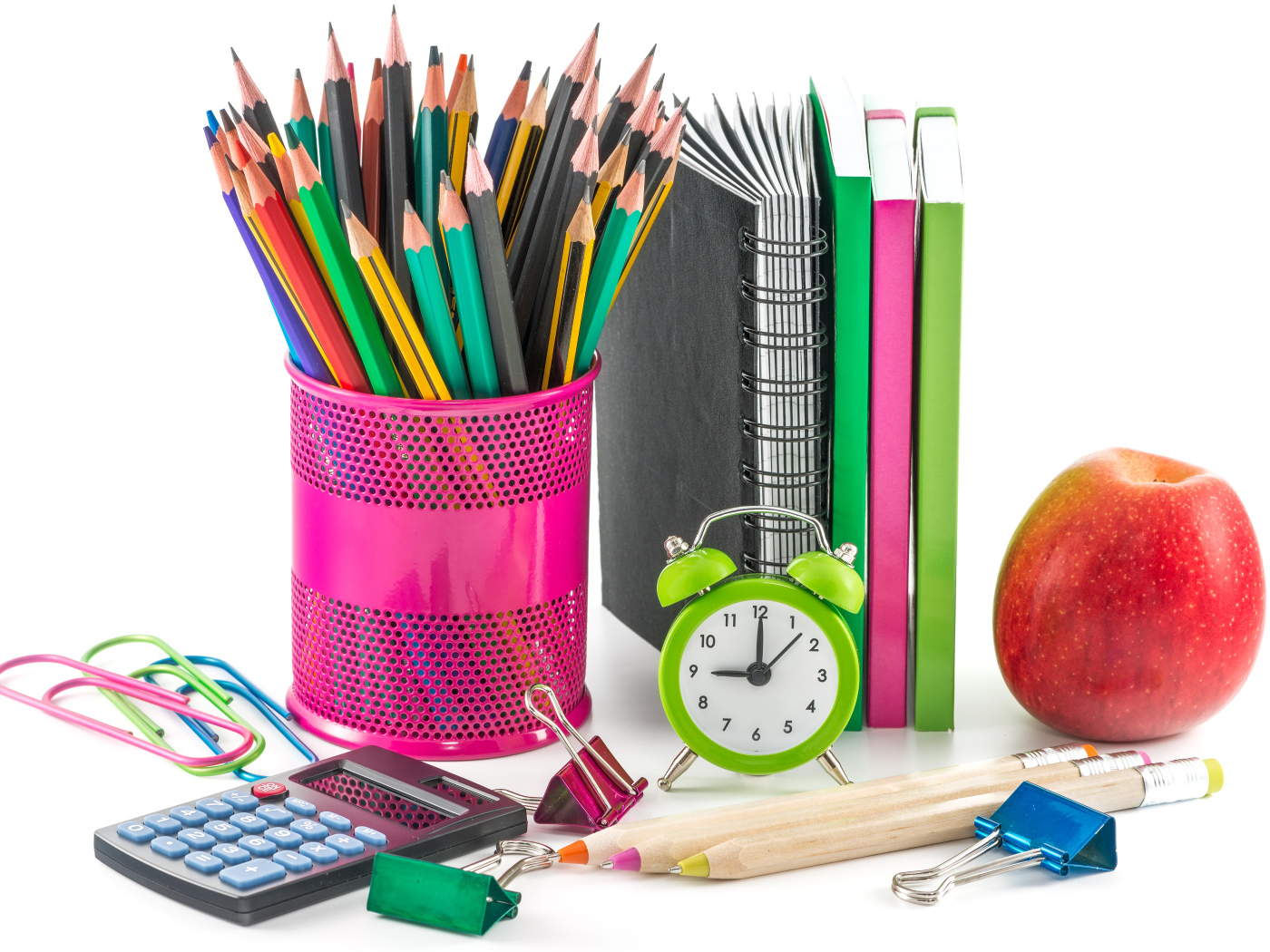 Канцелярские товары и красное яблоко на белом фоне