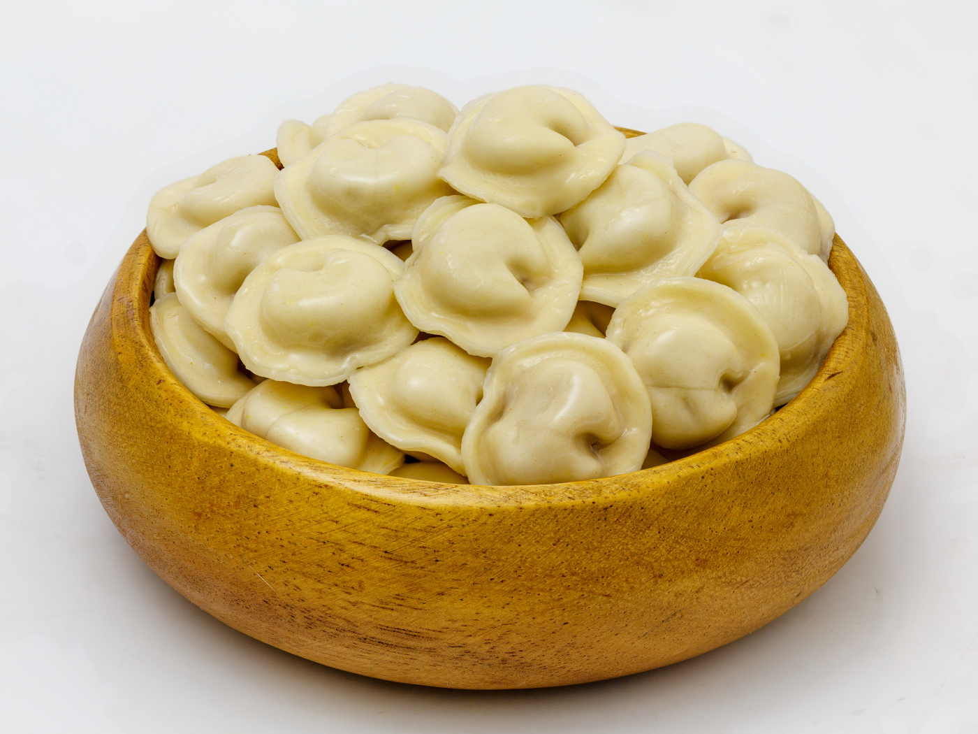 Аппетитные пельмени в деревянной миске на сером фоне