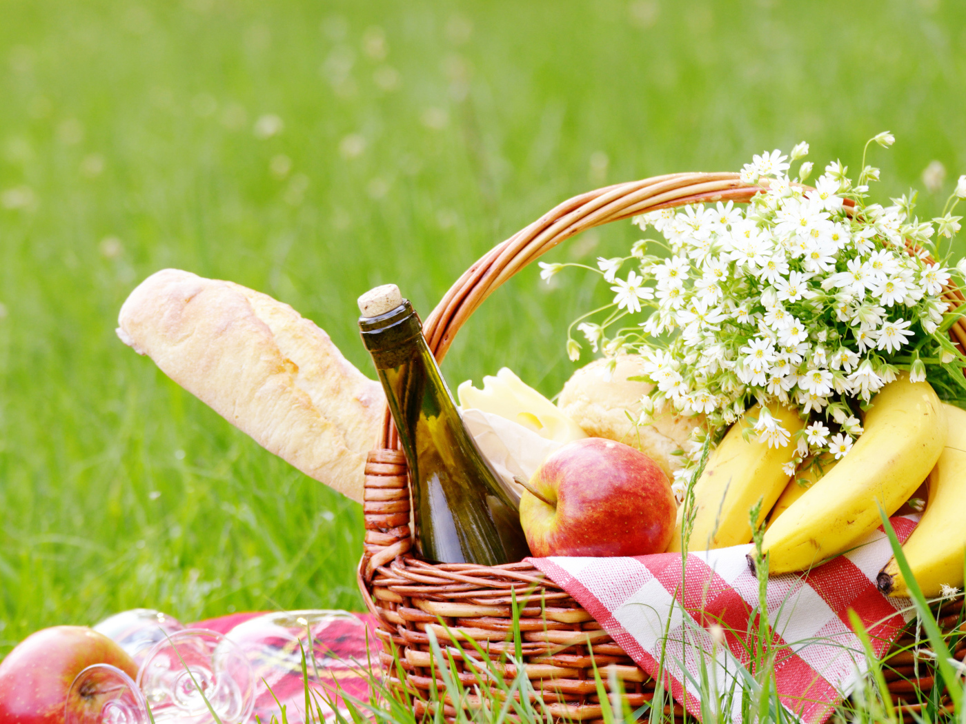 Корзина с продуктами для пикника и букетом белых ромашек