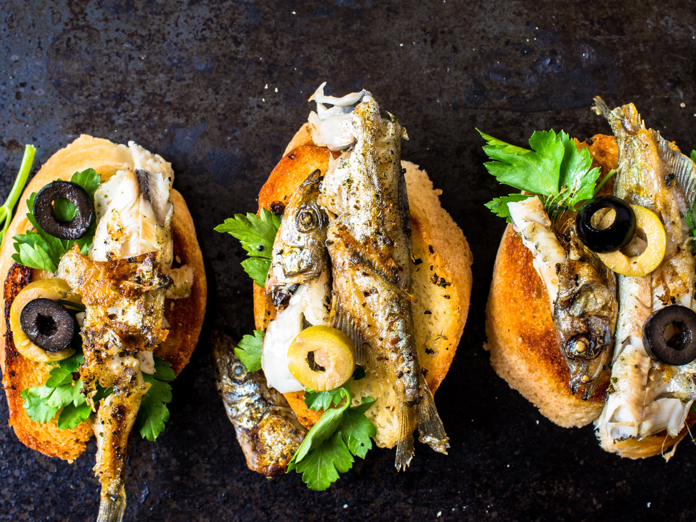 Гренки с жареной рыбой, оливками и зеленью