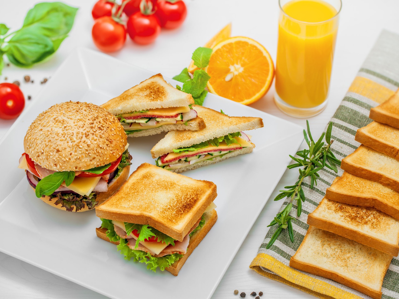 Гамбургер и сендвичи на столе с апельсиновым соком