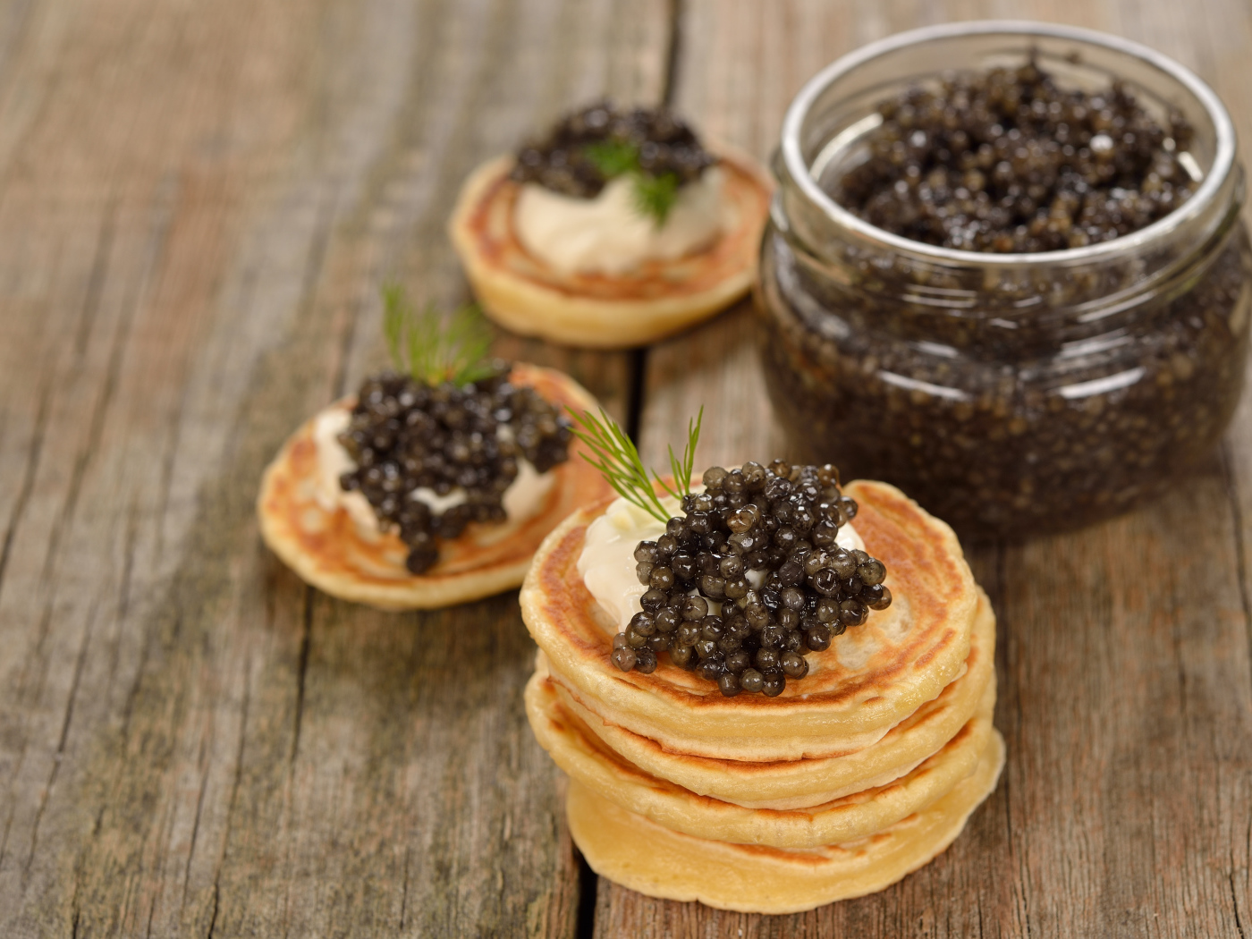 Оладьи с икрой и зеленью на столе