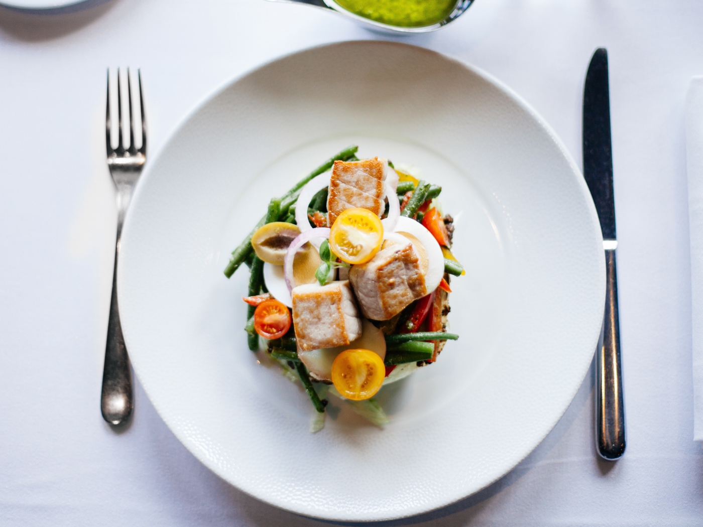 Овощной салат на белой тарелке со столовыми приборами