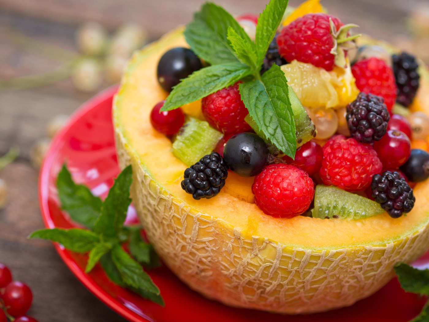 Аппетитные свежие ягоды с листьями мяты в половине дыни