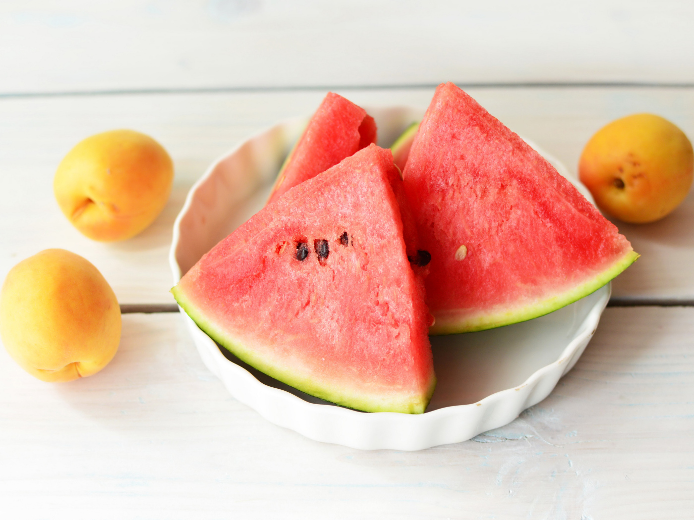 Кусочки сладкого арбуза с абрикосами на столе