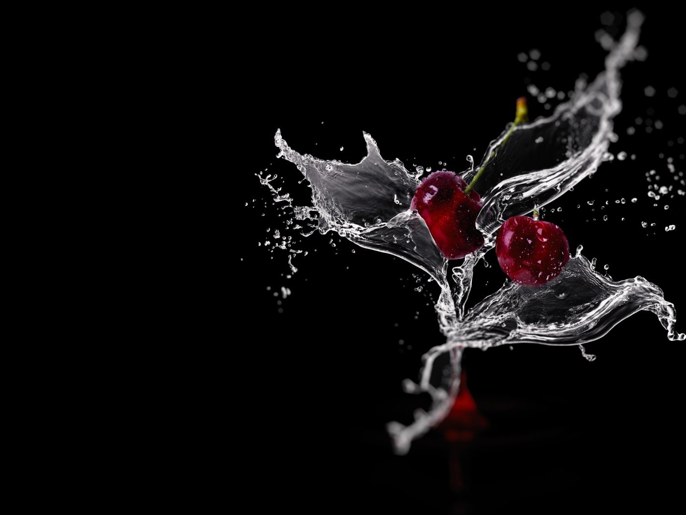 Две вишни в брызгах воды на черном фоне