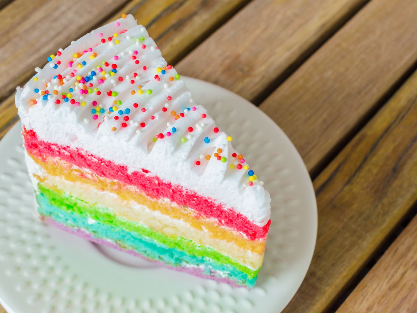 A piece of a multi-colored cake on a white plate