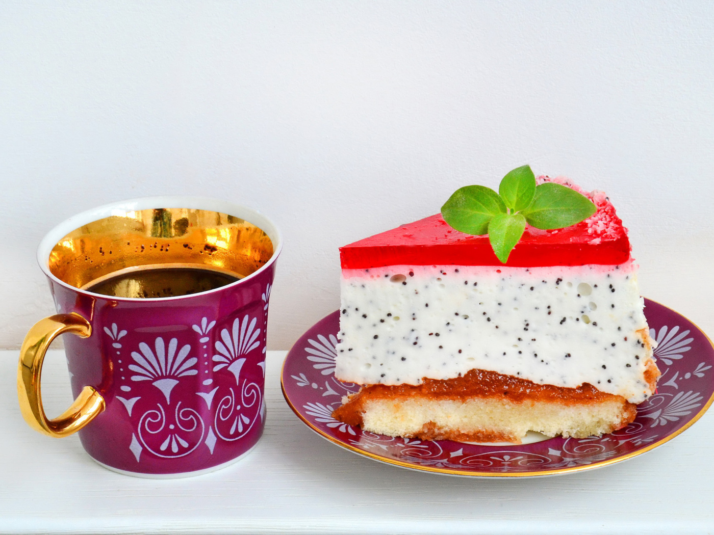 Кусок пирожного на тарелке с чашкой чая