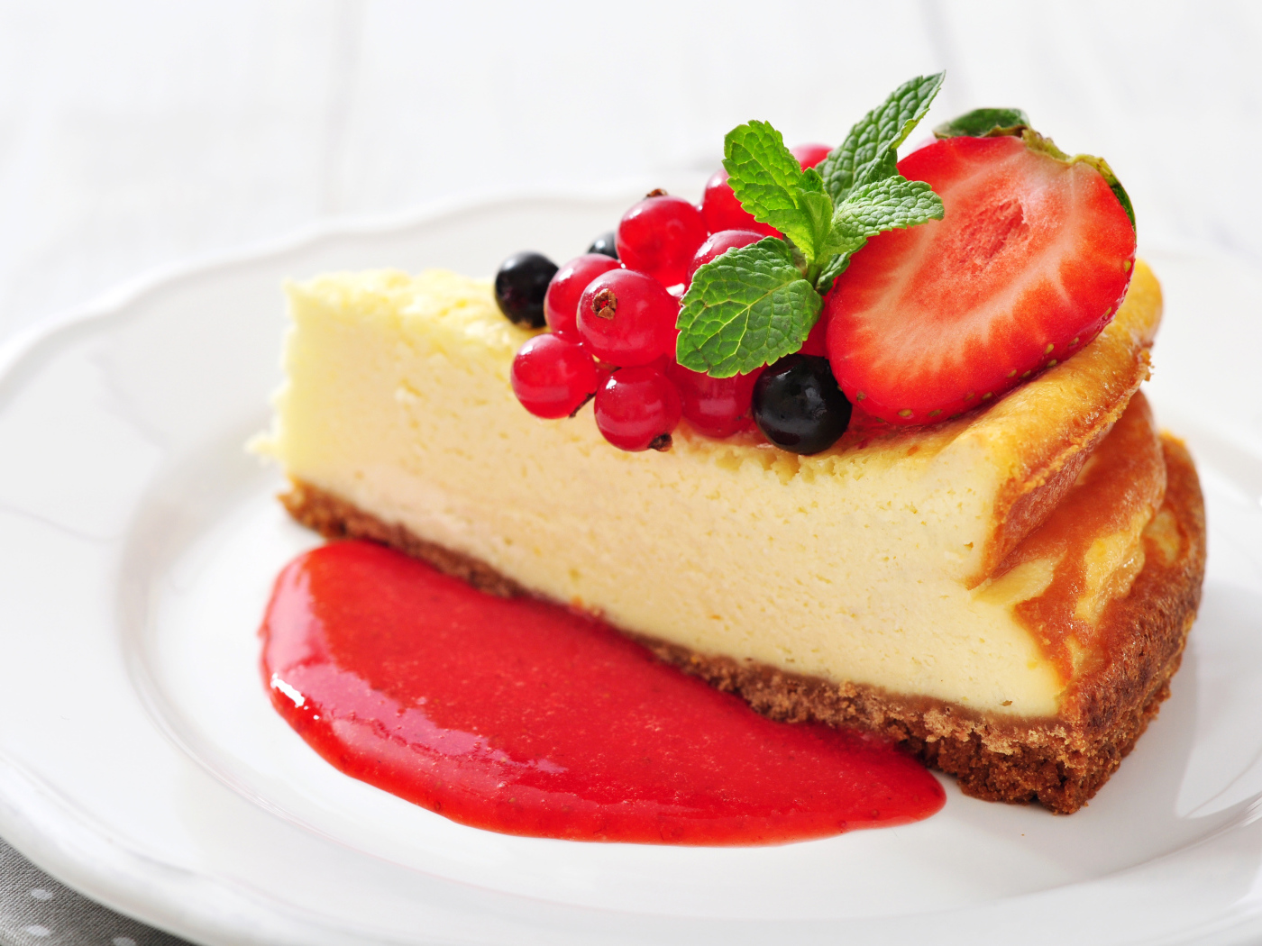 Кусок чизкейка с джемом и ягодами смородины и клубники