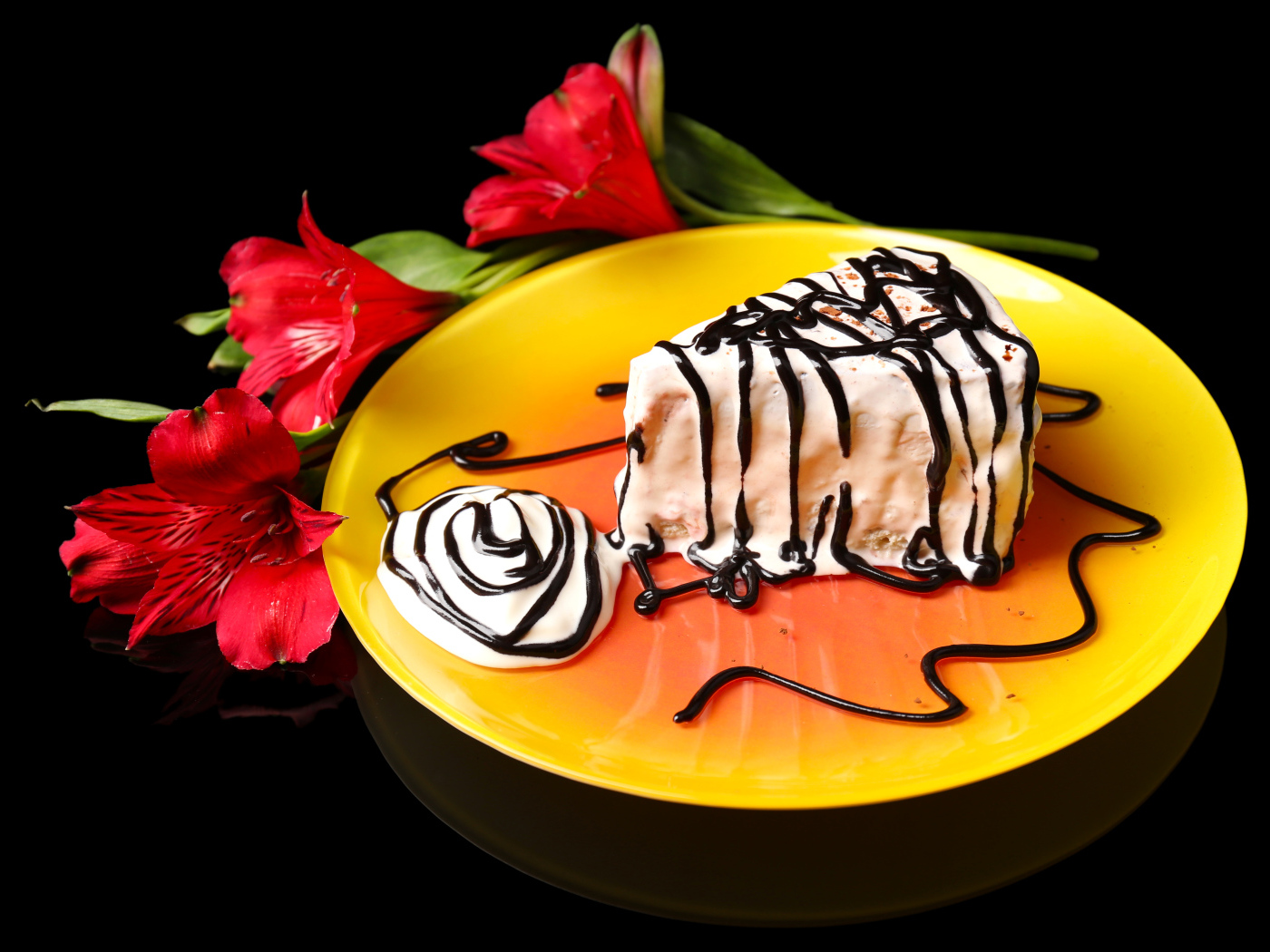 Аппетитное пирожное с шоколадом и цветком альстремерия на черном фоне