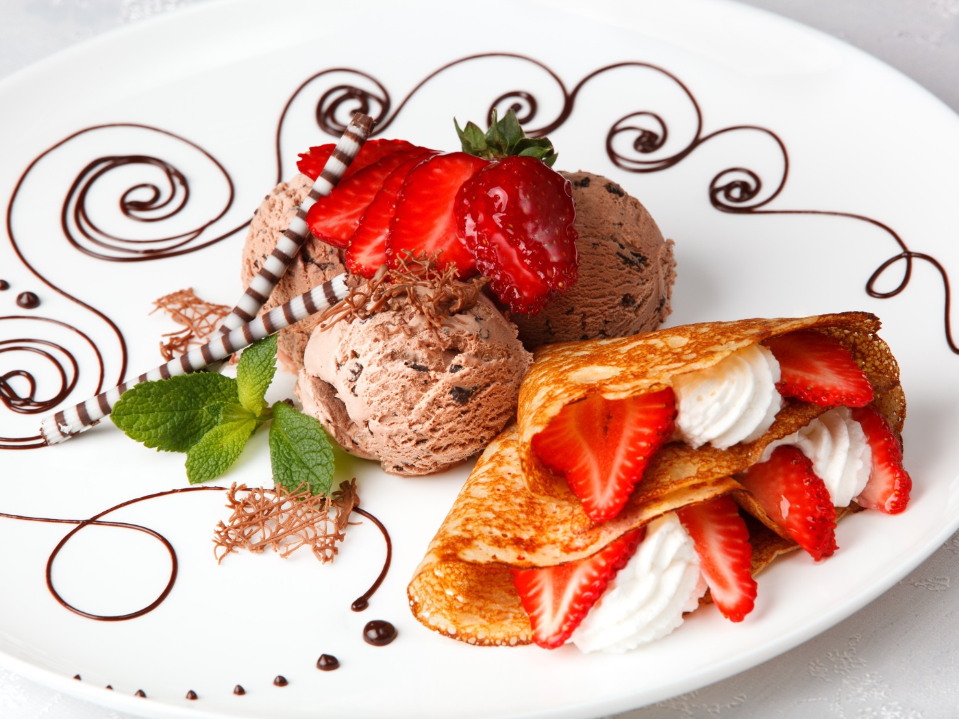 Шарики шоколадного мороженого с аппетитными блинчиками с клубникой