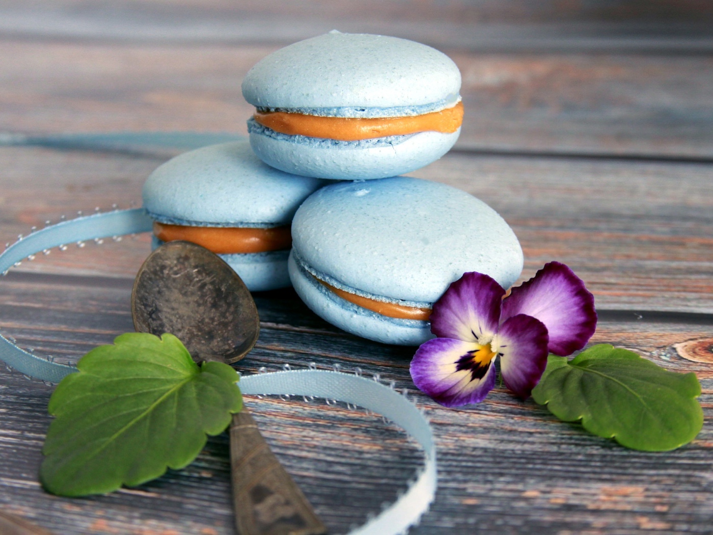 Голубые макаруны на столе с цветком 