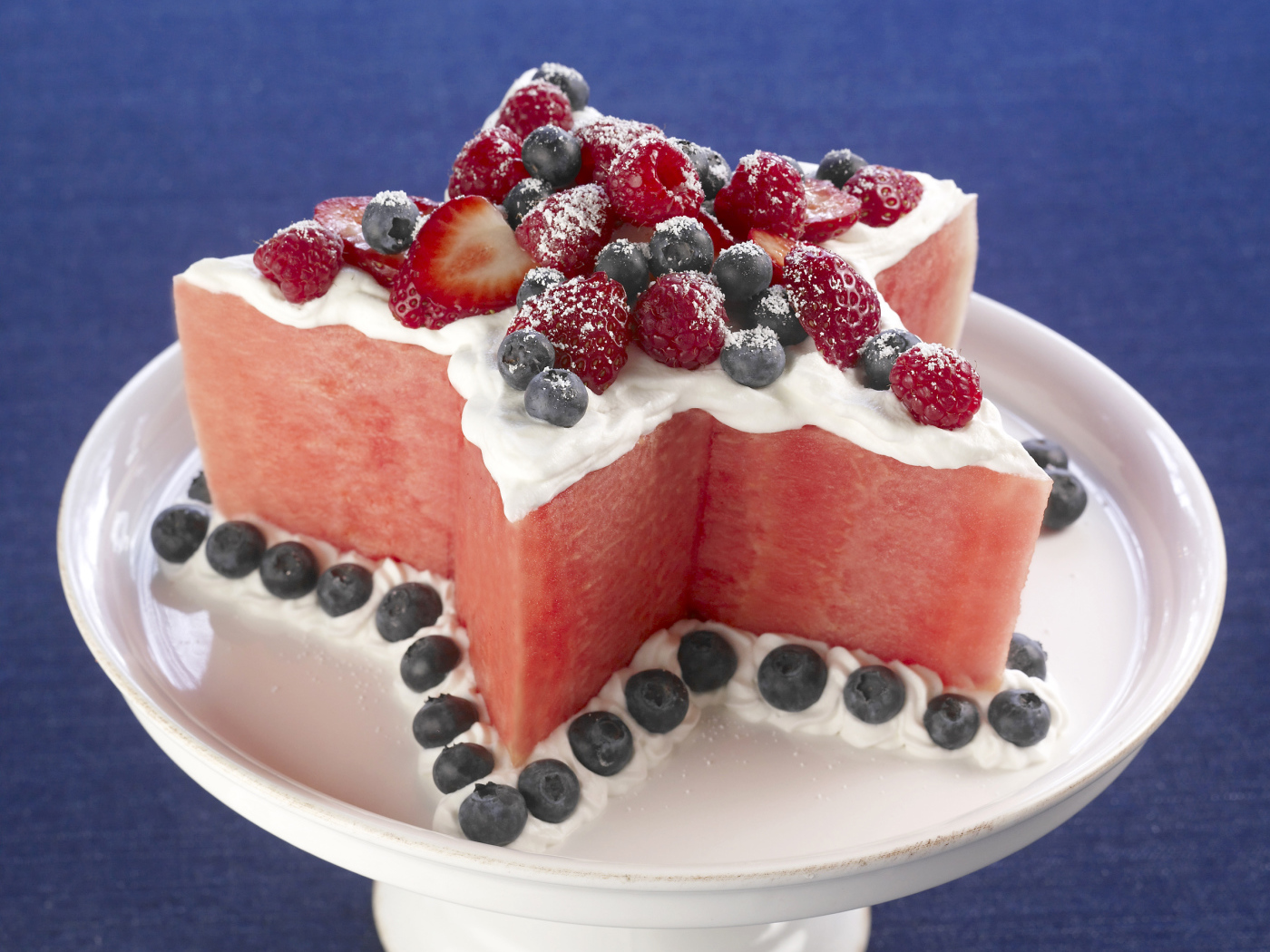 Десерт из арбуза со сливками и ягодами малины, клубники и черники