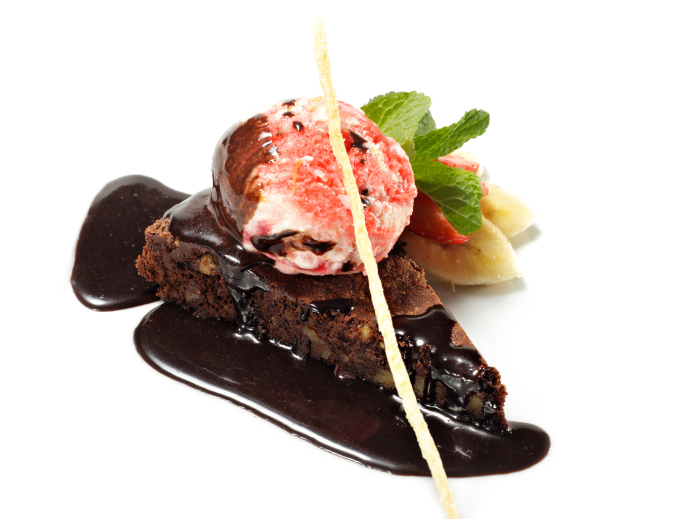 Кусок пирожного с шоколадом и шариком мороженого на белом фоне