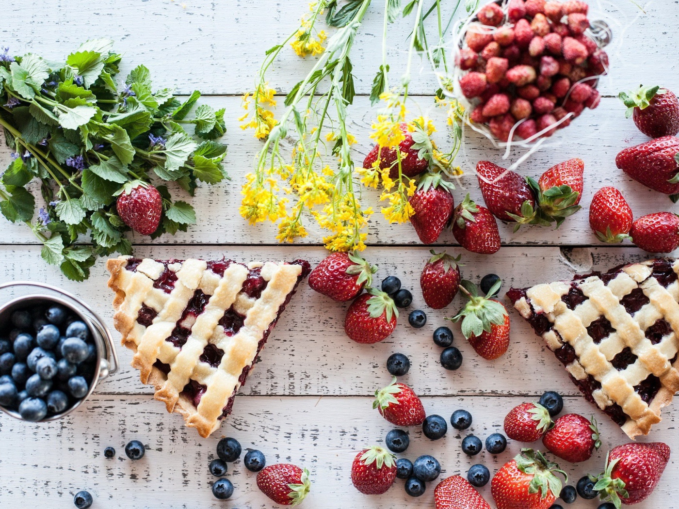 Кусочки пирога на столе с ягодами клубники и черники