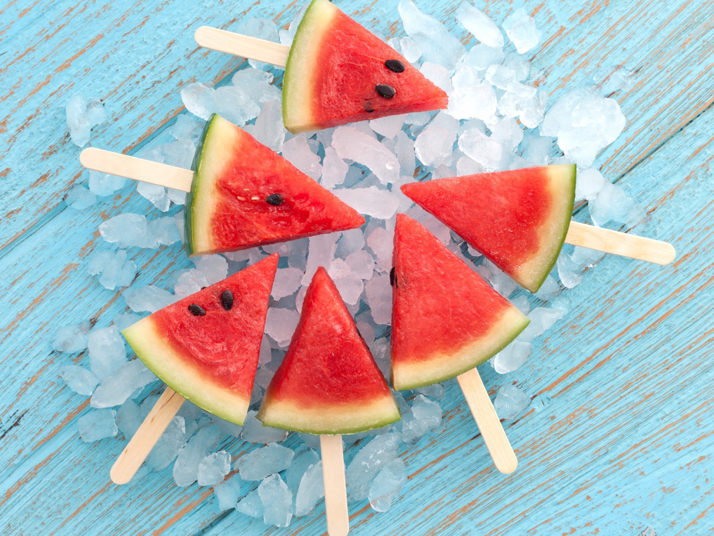 Кусочки арбуза на палочке лежат на льду