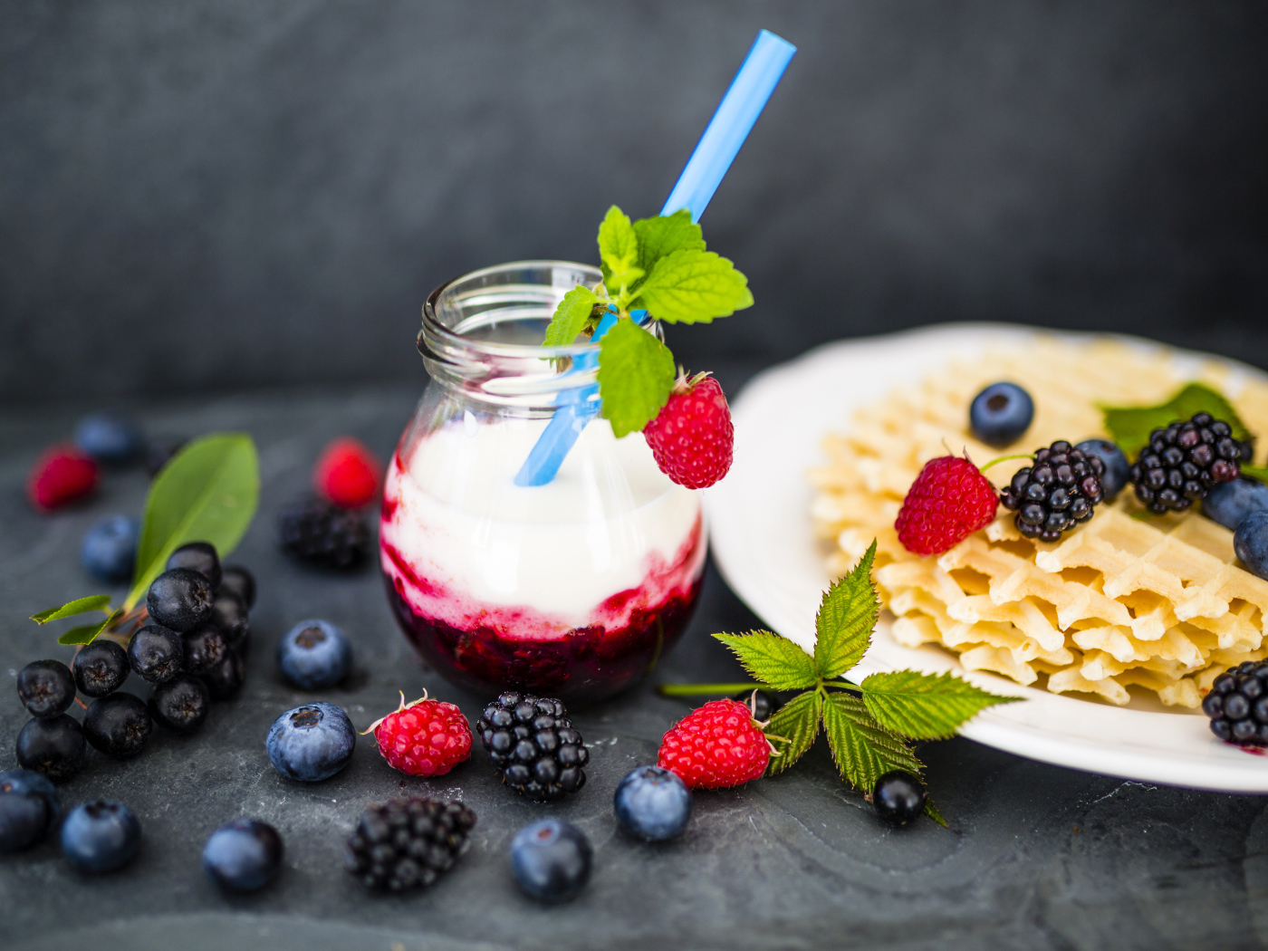 Тонкие хрустящие вафли на столе с ягодами и коктейлем