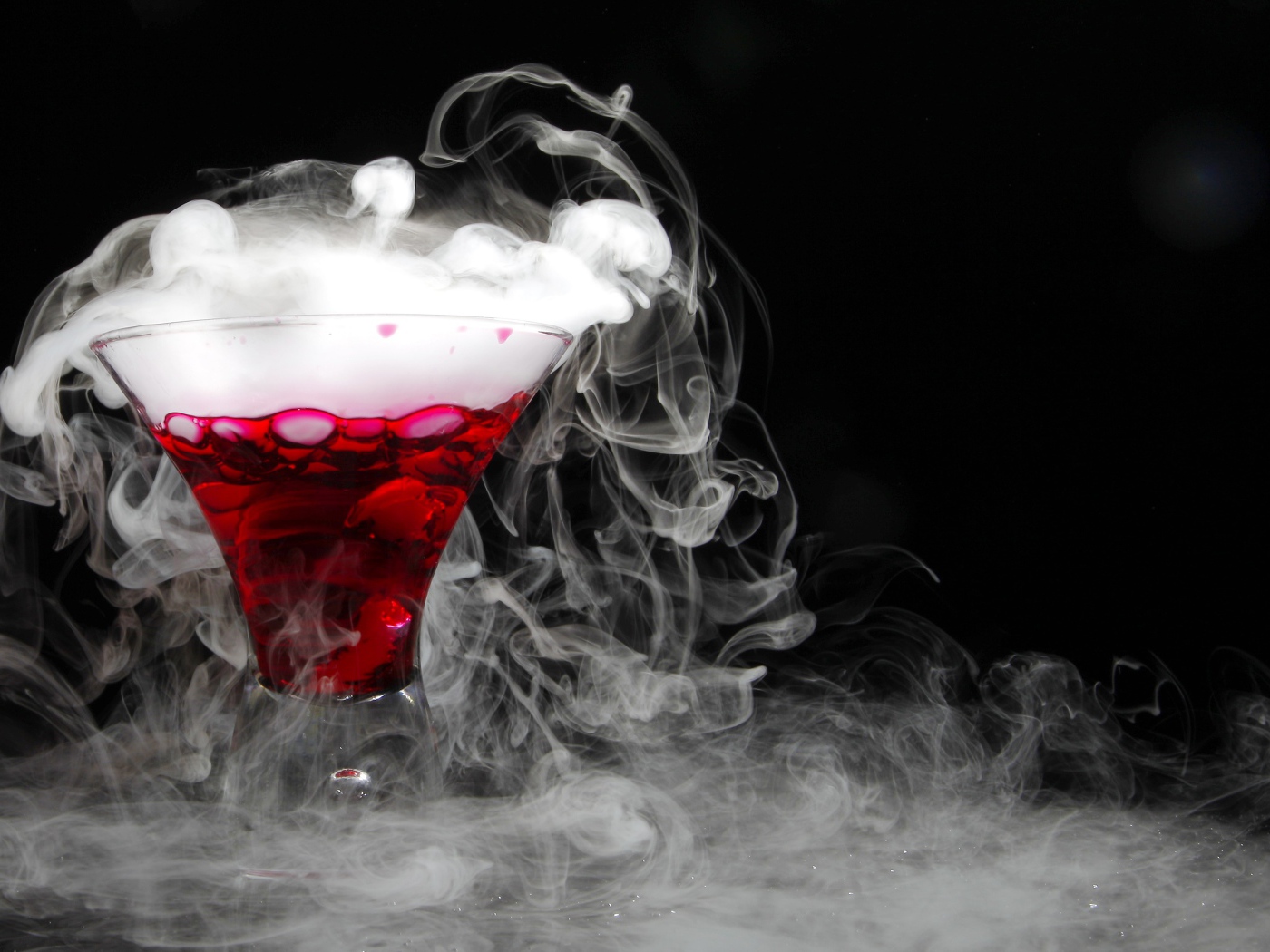 Коктейль с сухим льдом на черном фоне