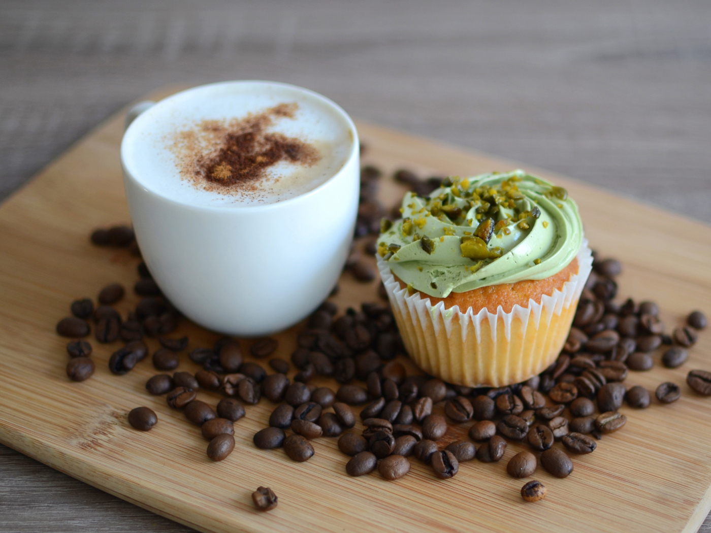 Кофе с аппетитным капкейком стоят на кофейных зернах