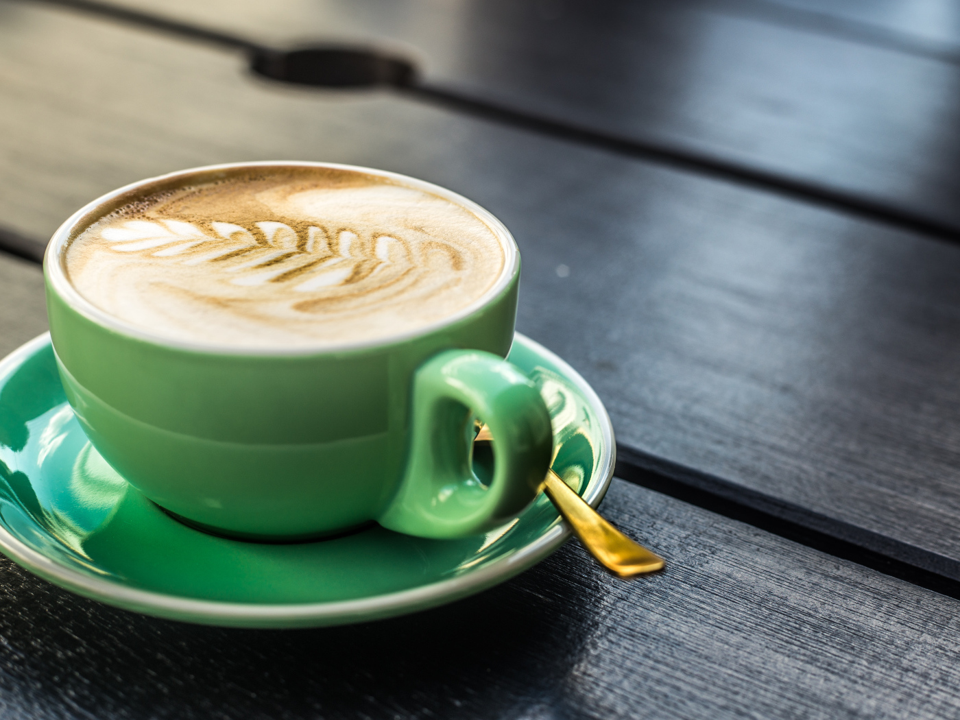 Зеленая чашка капучино с белой пенкой 