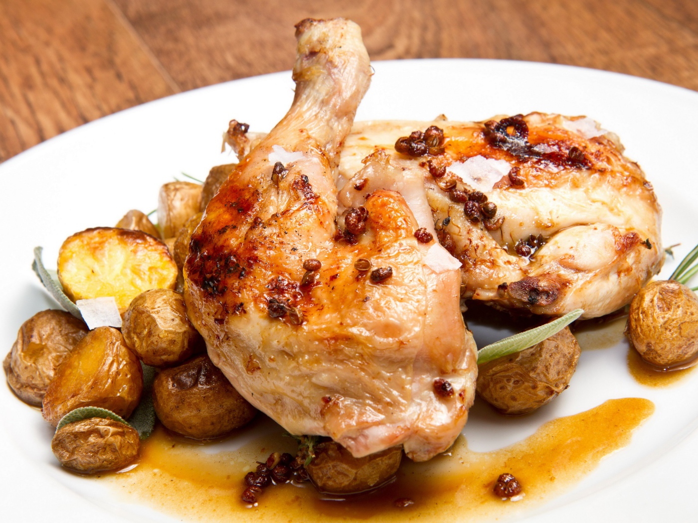 Жареные окорочка с картофелем на белой тарелке