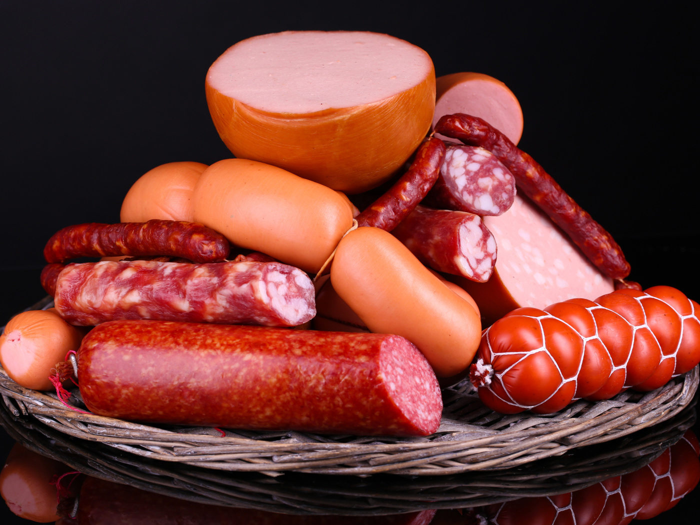 Мясные продукты колбасы и сосиски на черном фоне