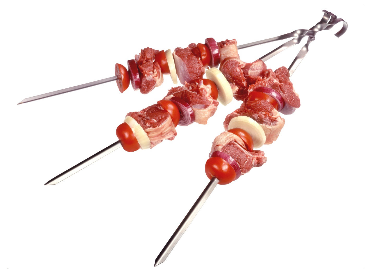 Мясо с овощами для шашлыка на шампурах на белом фоне